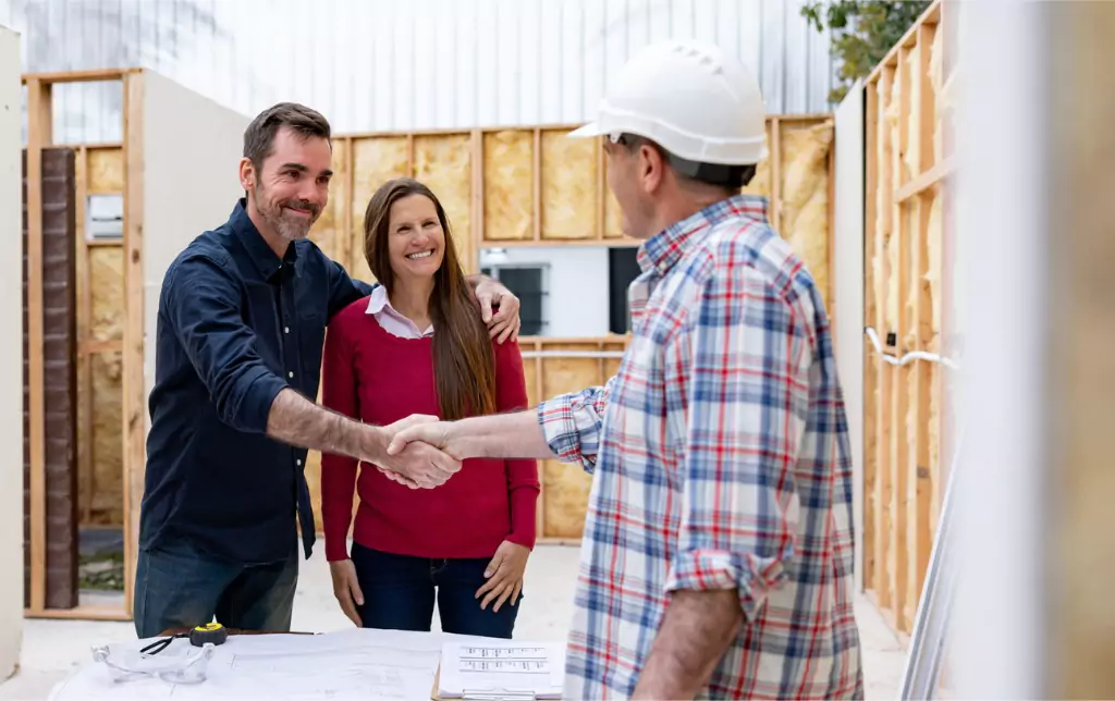 couple greeting the architect building their house with handshake